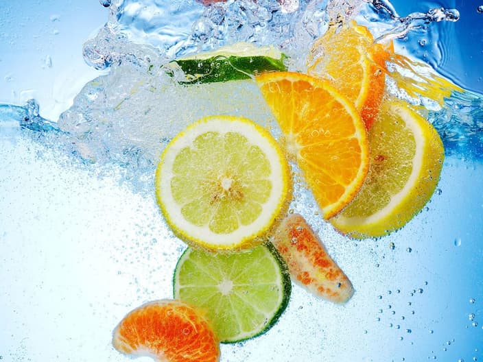Citric acid citrus fruits - Tropical fruits are falling deeply under water with a big splash