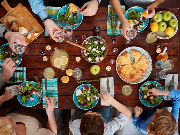 Multi-generation family having a delicious dinner with starters and courses - aerial shot