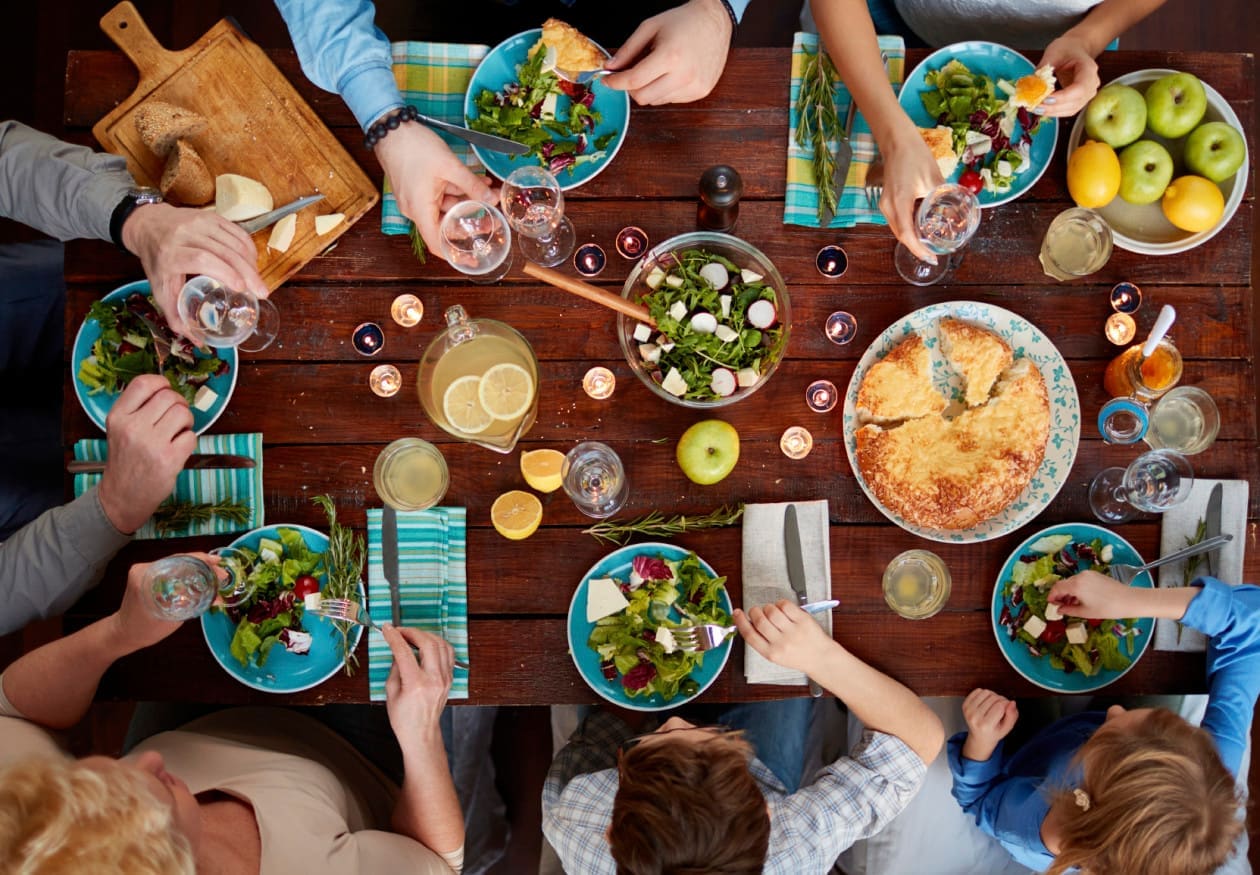 Multi-generation family having a delicious dinner with starters and courses - aerial shot