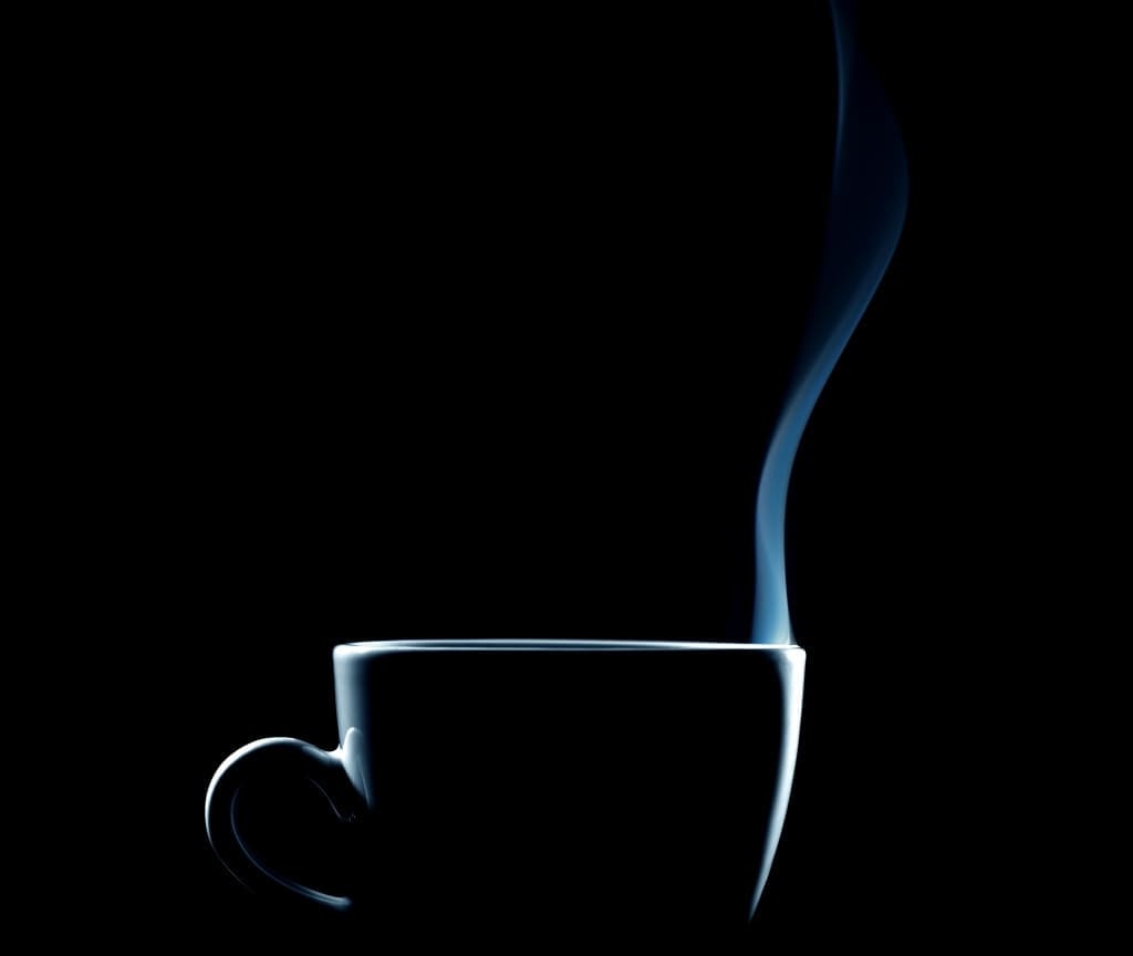 outline of a steaming coffee cup on black background