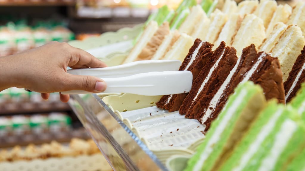 Hand holding Serving kitchen tongs in bakery shop