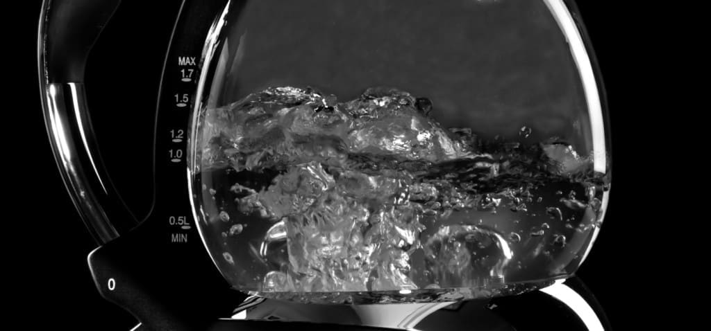 Making tea - Kettle with boiling water and steam isolated with clipping path on black