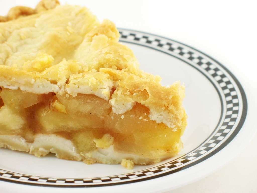 apple pie on a white and black checkered plate on white