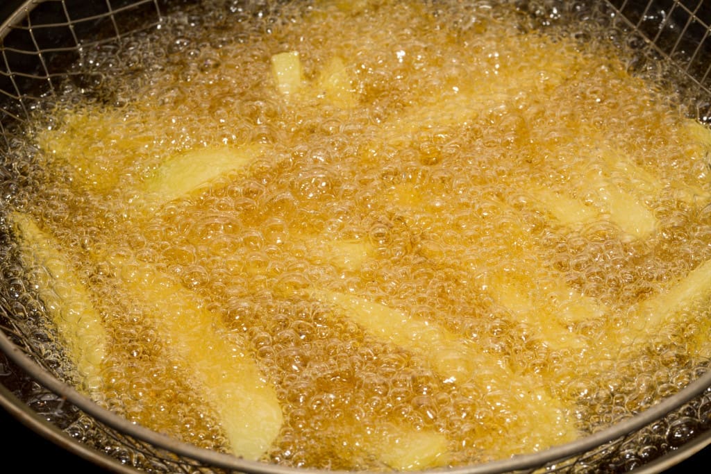 Frying french fries in deep fryer, closeup