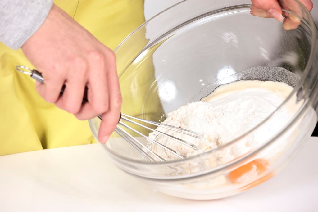 Woman whisking batter in kitchen
