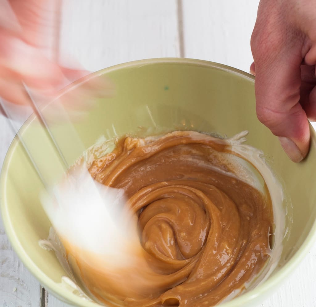 Making caramel cream stirring with spoon