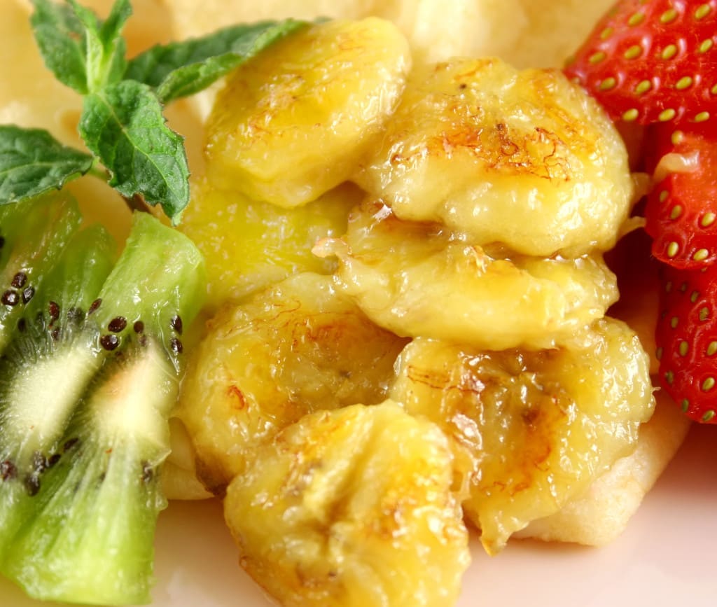 Caramelized banana crepes with strawberries and kiwi fruit.