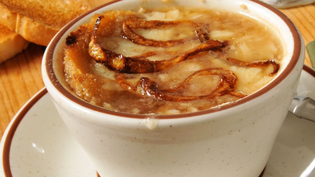 caramelized onions in A cup of French Onion soup with toast and gruyere cheese