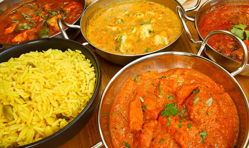 Selection of indian food with pilau rice, naan bread, poppadoms and samosas a popular choice for eating out in european countries