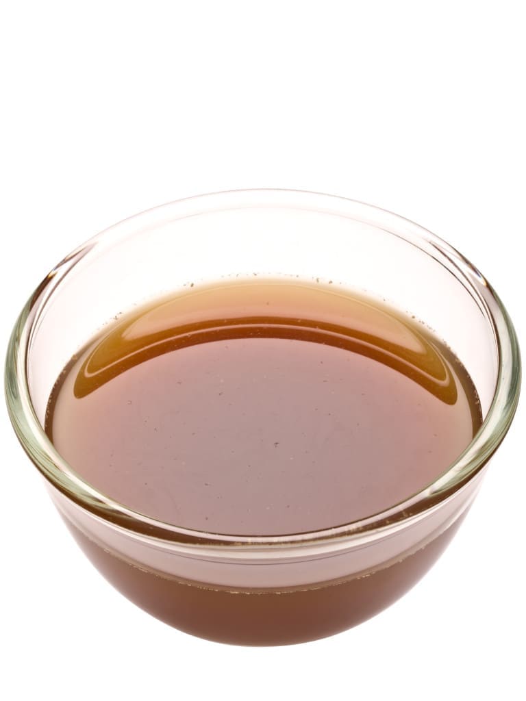 close up of a bowl of beef stock isolated