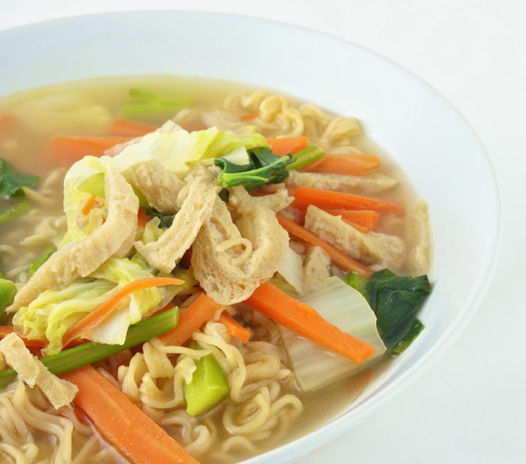 Egg noodle and clear soup vegetarian for health. It include vegan protein dry, carrot, kale and cabbage on white background.