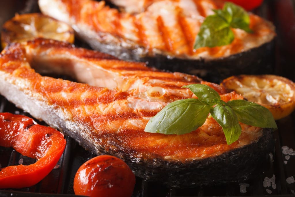 pan fried - Delicious salmon steak and vegetables on the grill, macro. horizontal