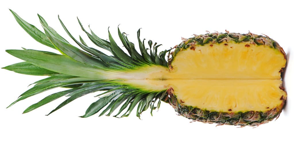 there is less bromelain proteases in the stem - ripe whole pineapple with a quarter cut isolated on white background