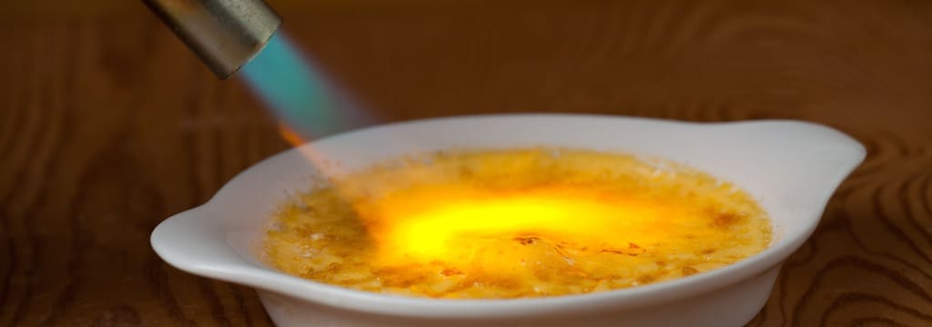 torching of the top layer of sugar on creme brulee is done briefly