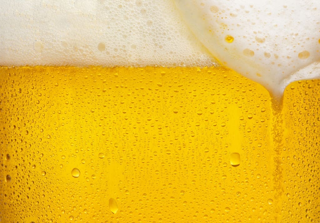 Creamy foam on beer and carbon dioxide bubbles
