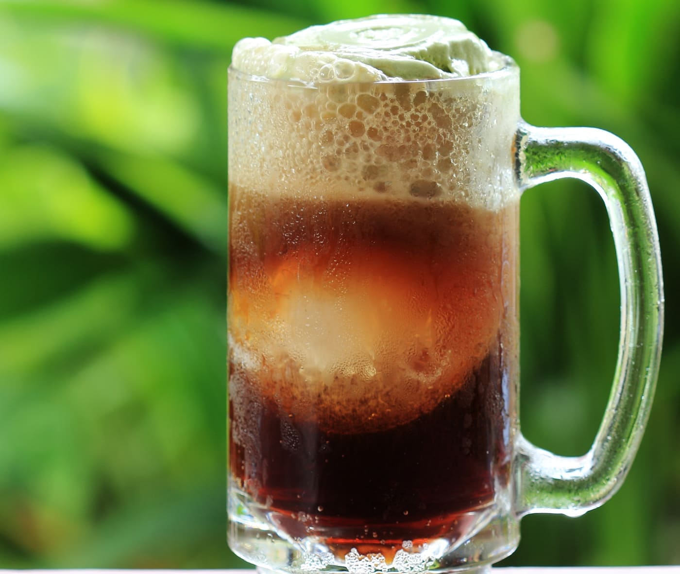 Ice cream float - ice cream and the air inside provides additional nucleation sites for CO2 bubbles - Root beer float a tasty summer treat on Green tree background