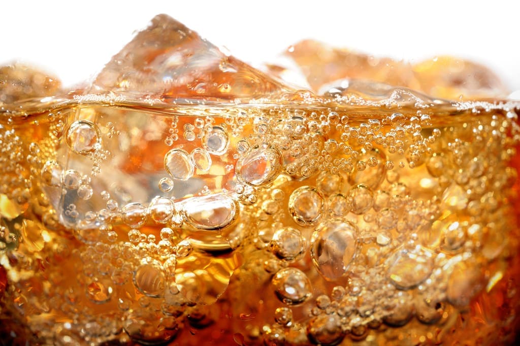carbon dioxide bubbles are pressurized hence when you pop a can or bottle of soda, they cannot wait to escape