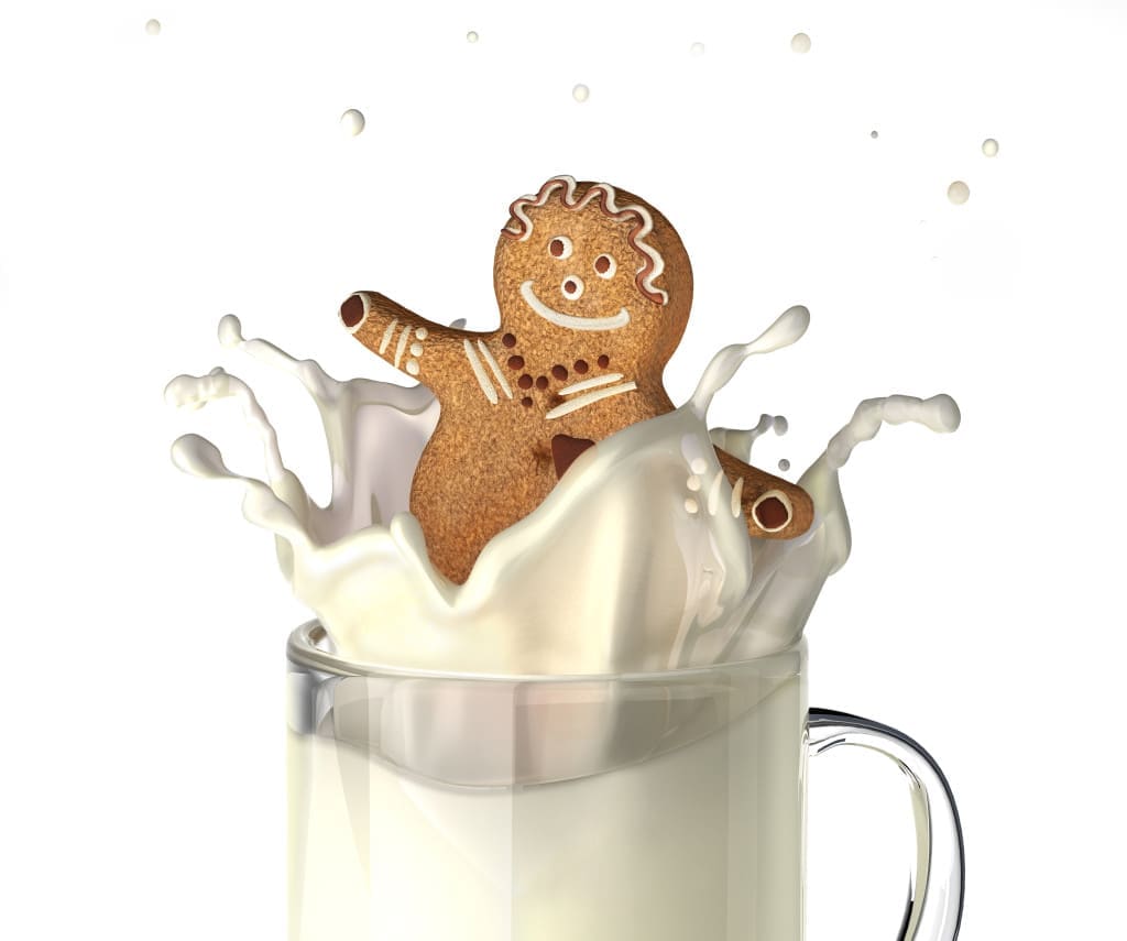 Sweet human character shaped bisquit, splashing into a glass mug full of fresh milk. On white background
