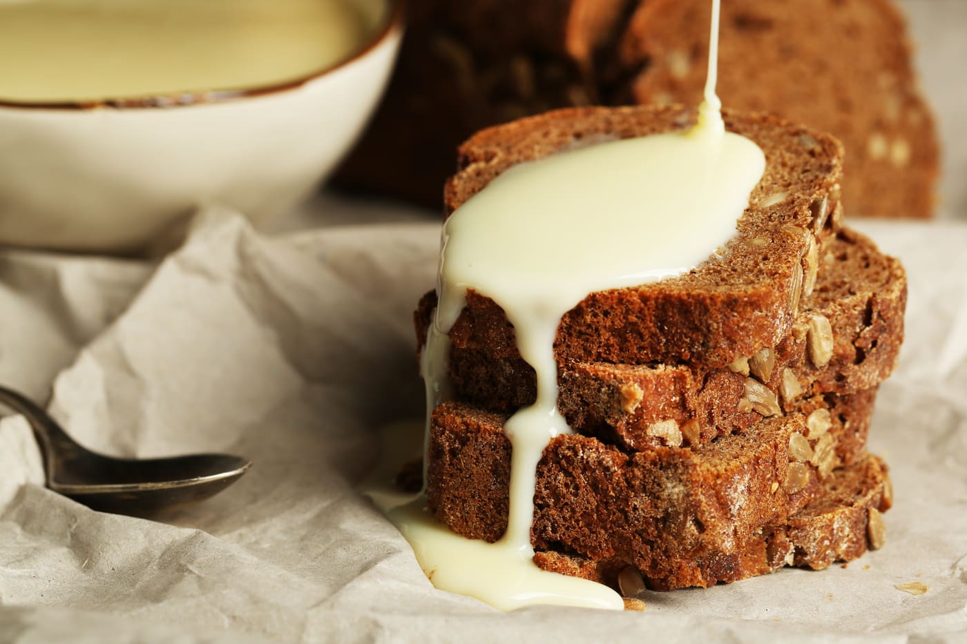 Slices of bread with sweetened condensed milk on paper background