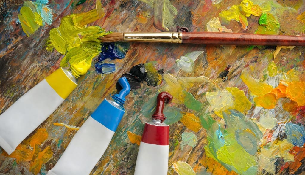 Palette with paint brush and tubes of oil paint